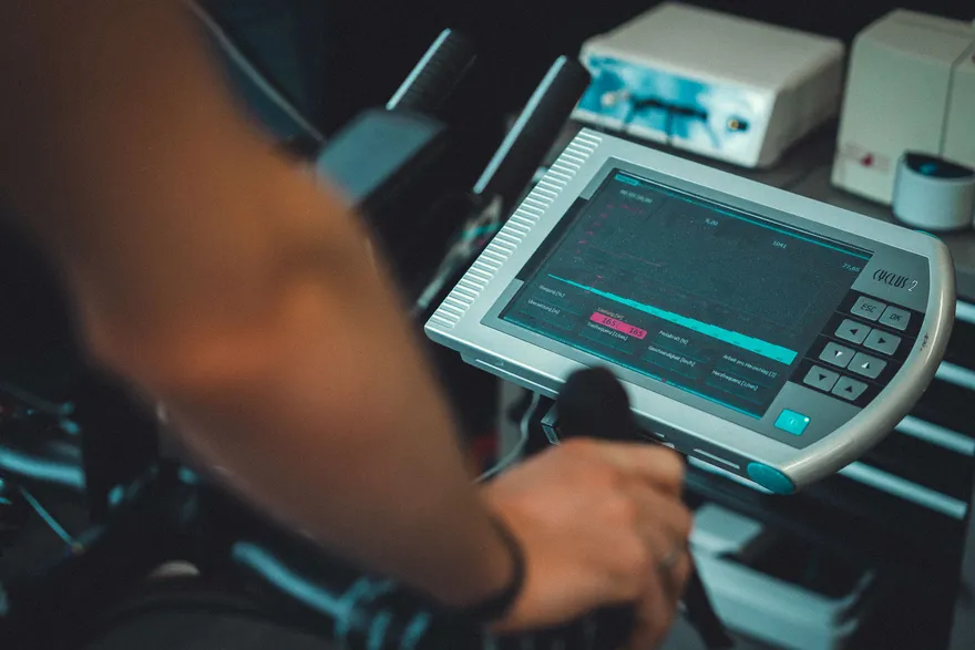 Hand am Lenker neben dem Display des Smarttrainers während des Testprotokolls