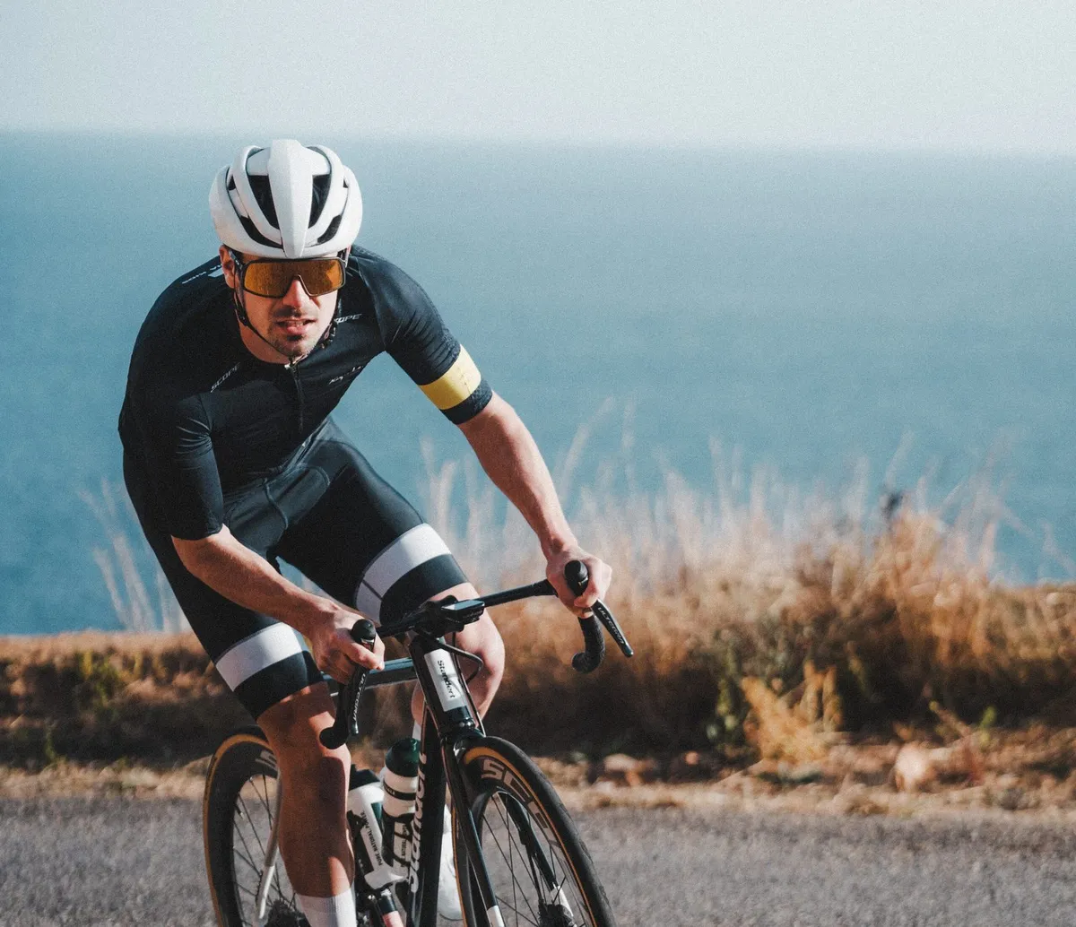Rennradfahrer auf einer Küstenstraße im SCYENCE-Trainingscamp in Girona